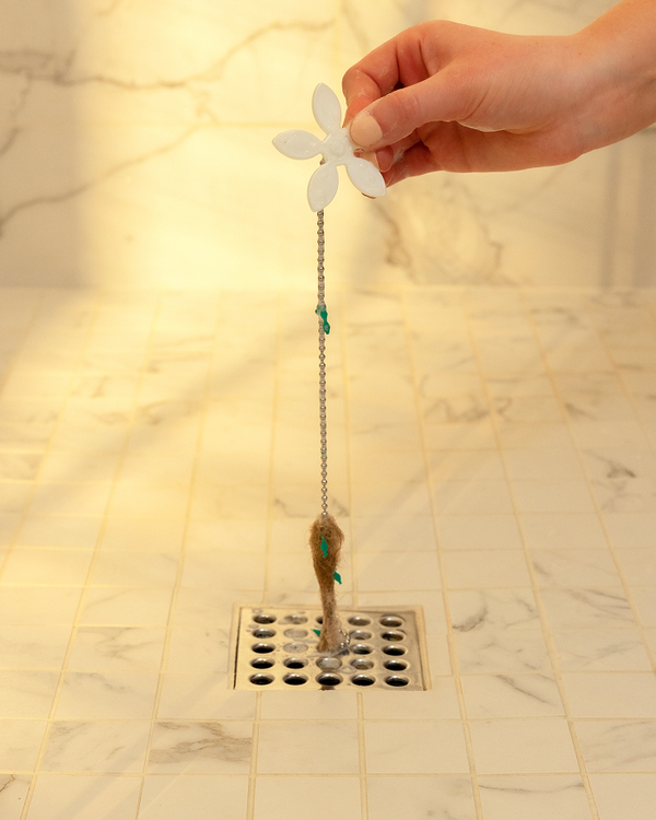 DrainWig hair catcher pulling hair out of shower drain